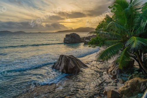 Preview: Beautiful scenery of a rocky shore of an exotic island at sunrise under a cloudy sky in Seychelles