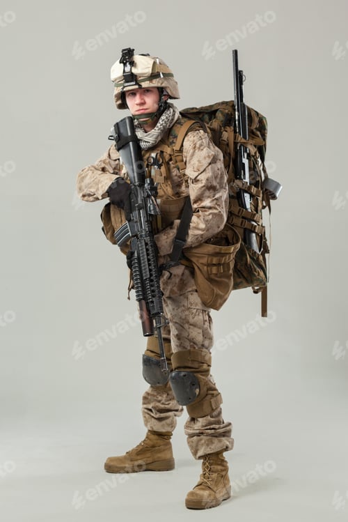 Preview: Military soldier poses with firearm and gear in studio setting during training session