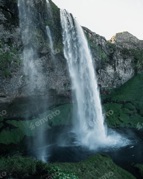 Preview: Breathtaking view of a powerful waterfall surrounded by rocky cliffs in Iceland