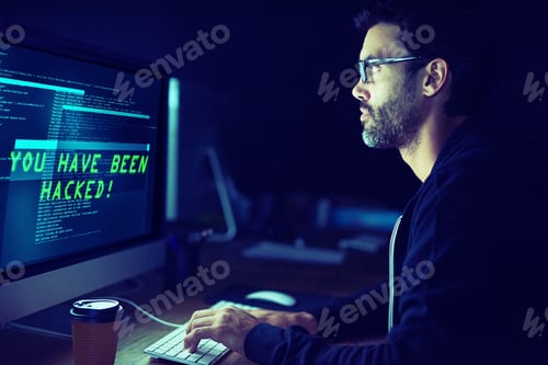 Preview: He could be coming for you. Shot of a focussed computer hacker using a computer in the dark.