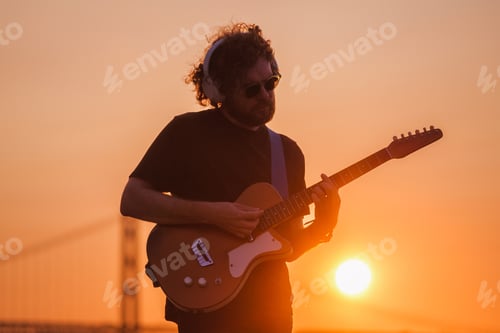 Preview: Man Plays Guitar at Colorful Sunset Scene