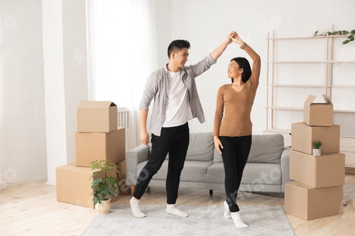 Preview: Happy asian man and woman dancing in new flat