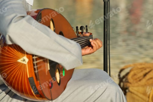 Preview: Middle East unrecognizable musician wearing traditional clothing plays a multi string oud instrument