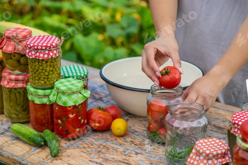 Preview: A woman preserves vegetables in jars. Selective focus.