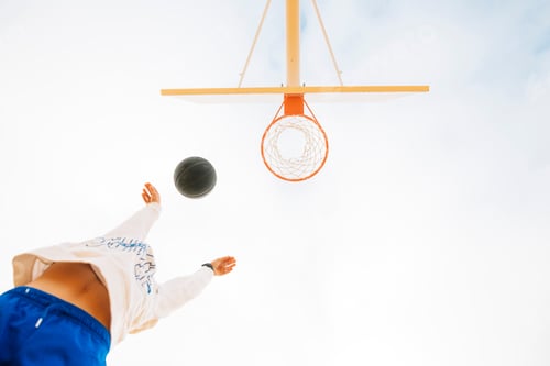 Preview: Young boy playing on yellow basketball court outdoor.