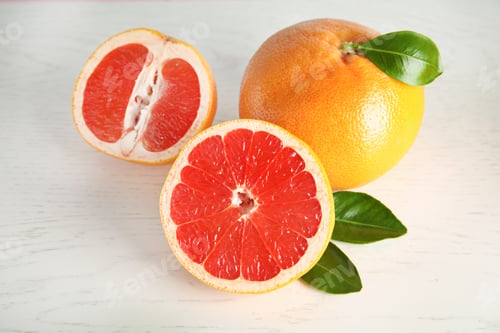 Preview: Whole and sliced tasty grapefruits on white background