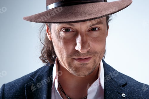 Preview: Young Man Portrait With Hat On Gray Studio Background.