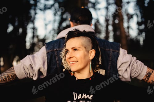 Preview: Young guy and happy lady standing back to back in forest