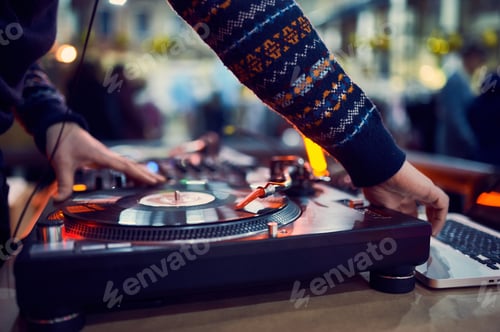 Preview: turntable, hand of dj on the vinyl record at night club. blured background