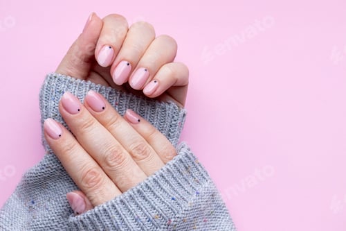 Preview: Female hands in a gray knitted sweater with trendy beautiful manicure - pink nude nails
