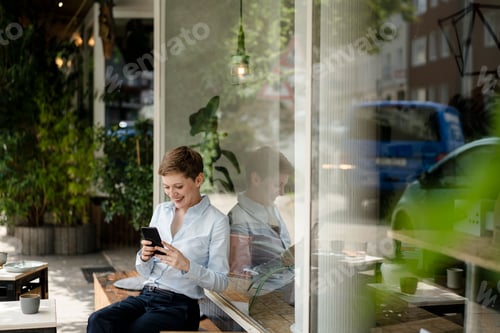Visualização: Mulher de negócios usando telefone celular em um café