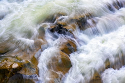 Preview: Aerial view of river waterfall with clear turquoise water falling down between wet boulders with