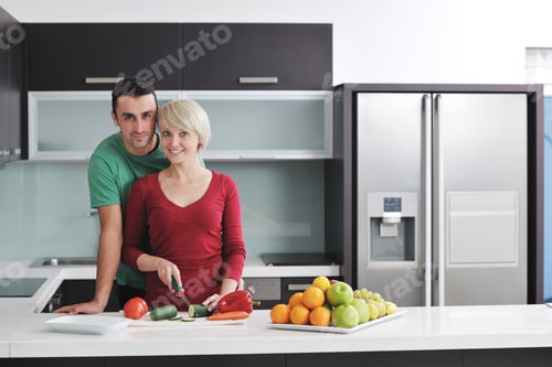 Preview: Happy Young Couple Have Fun In Modern Kitchen Indoor While Preparing Fresh Fruits And Vegetables