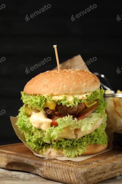 Preview: Burger with delicious patty on wooden table against dark background