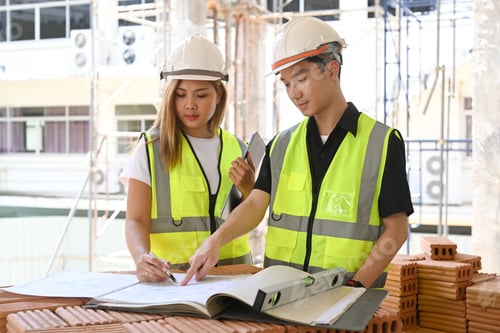 Preview: Civil engineer and specialists working, checking plan together at construction site.