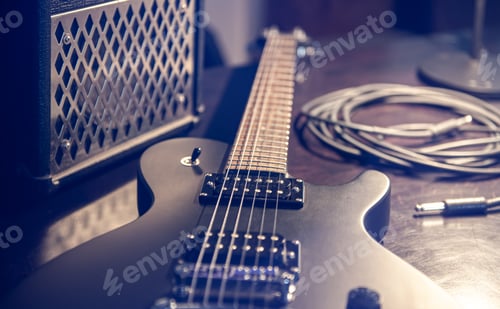 Preview: Close-up, black electric guitar on a dark background.