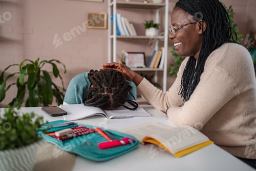 Preview: Mother comforting tired daughter doing schoolwork at home