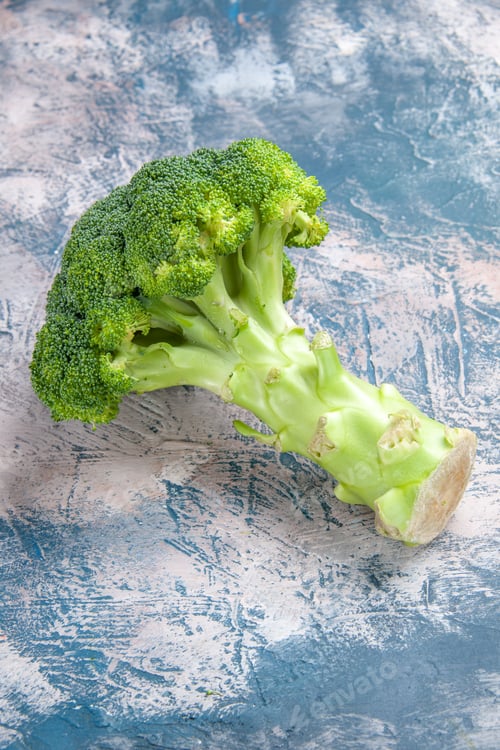 Preview: Vertical view of fresh vitamin bom green broccoli on gray background