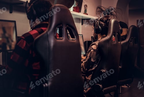 Preview: Team of teenage gamers plays in a multiplayer video game on pc in a gaming club.