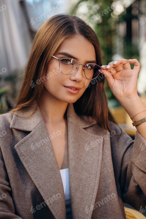 Preview: Wearing the glasses. Pretty young woman is outdoors