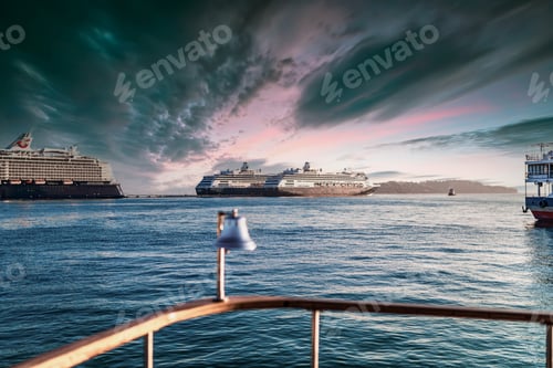 Preview: Huge cruise ships sail under dark stormy clouds at sunset