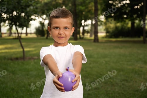 Preview: Cute little boy holding water bomb in park