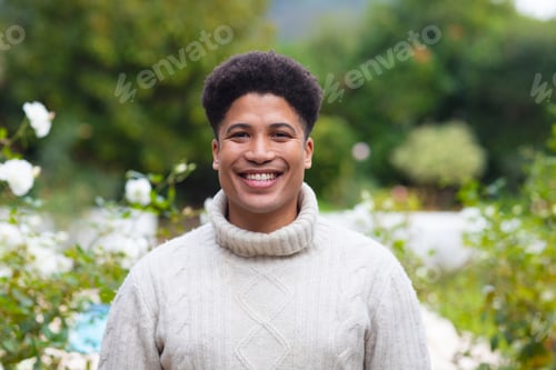 Preview: Portrait of happy biracial man smiling to camera in garden