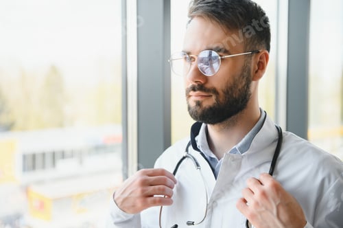 Preview: Portrait of young male doctor with stethoscope, close up