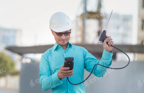 Preview: man in a shirt and a white helmet is standing at a construction site