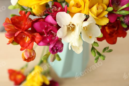Preview: Beautiful spring freesia flowers on table, closeup