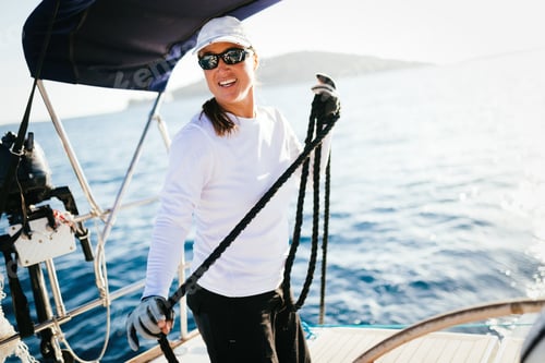 Preview: Attractive strong woman sailing with her boat