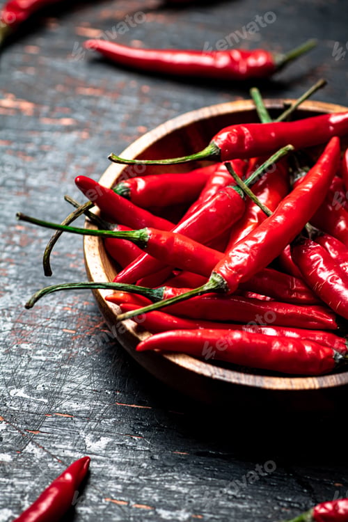 Preview: Wooden plate with hot chili peppers.