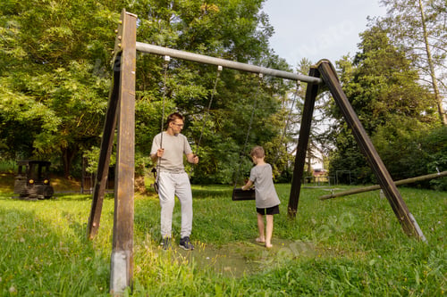 Preview: A father and his child share joyful moments on a playground. They swing and laugh together