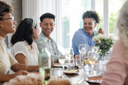 Preview: Friends enjoying conversation and laughter at wedding reception table with drinks
