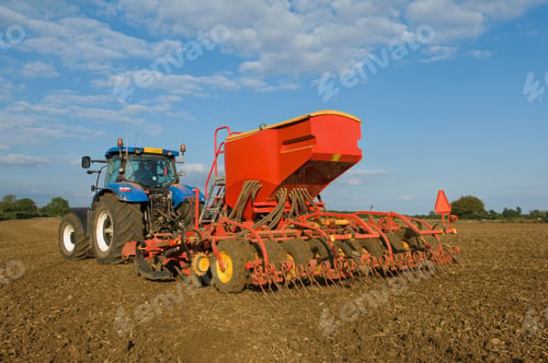 Preview: Farmer driving tractor and drilling seed corn in field
