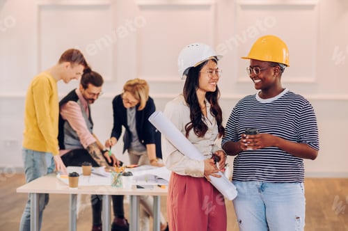Preview: Portrait of two diverse architect posing in an office during a meeting