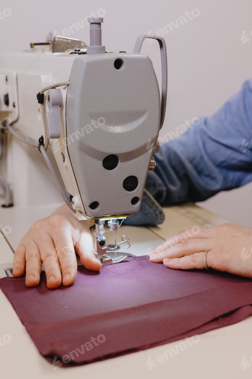 Preview: woman sews piece of cloth on sewing machine. industrial metal machine for all fabric tops.
