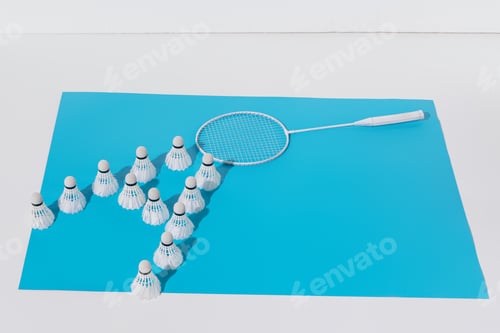 Preview: composition with white badminton racket and shuttlecocks on blue paper