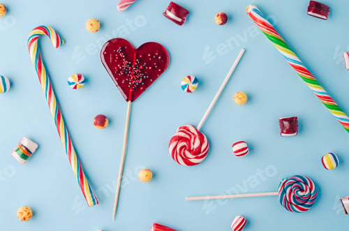 Preview: High angle shot of candy canes and lollipops on a light blue background