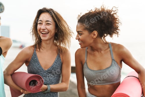 Preview: Three cheerful young sport girls standing at the beach