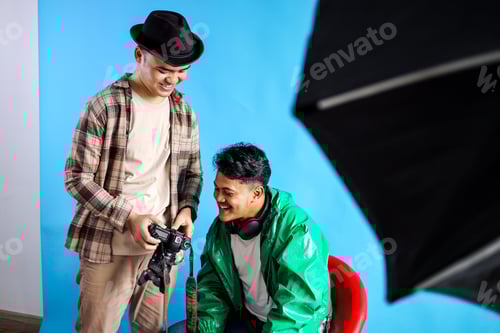 Preview: Two Young Men Working Together with Camera in Studio Setting
