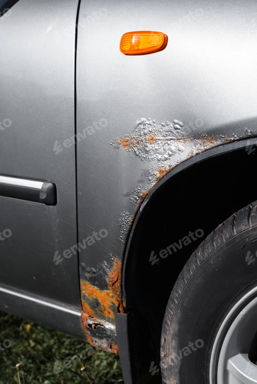 Preview: Corrosion of the car. Rust, corroded gray paint on the front fender of the car. Vertical photo