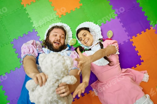 Preview: Funny man and woman babies playing with teddy bear top view