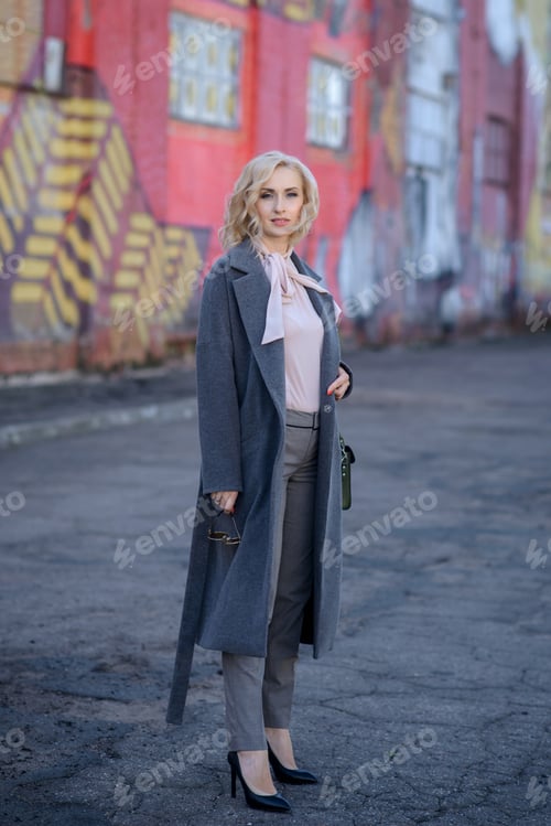 Preview: beautiful business girl walks around the city in a coat. Walk