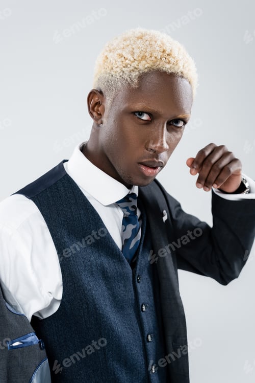 Preview: blonde african american man with blue eyes looking at camera isolated on grey