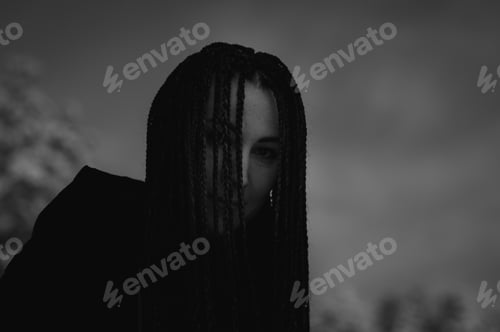 Preview: Woman silhouette at night in darkness. Woman with many braids