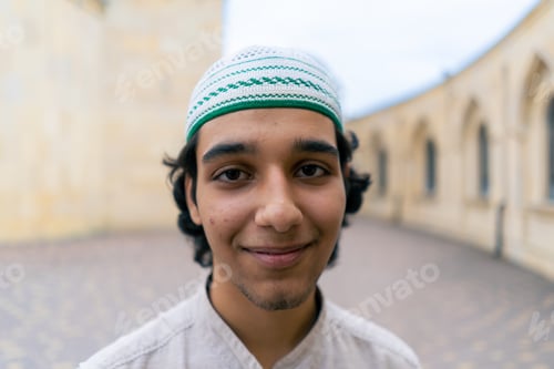 Preview: portrait of a young Arab man looking into the camera against the background of a Muslim mosque