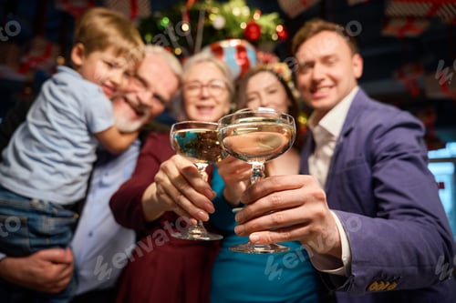 Preview: People holding glasses with champagne celebrating New Year in restaurant