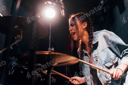 Preview: Plays drums. Young beautiful female performer rehearsing in a recording studio