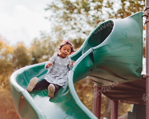 Preview: Happy 3 year old sliding down a slide at the park